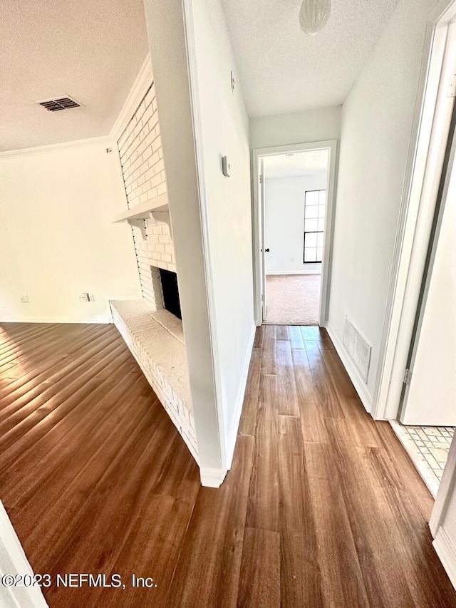 hall with hardwood / wood-style flooring and a textured ceiling