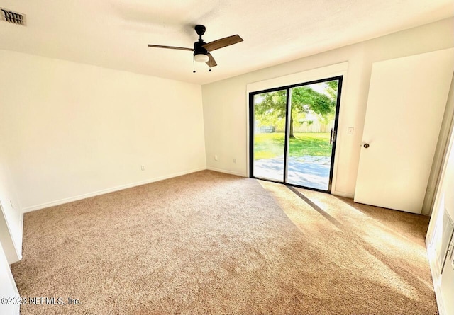 spare room with ceiling fan and carpet