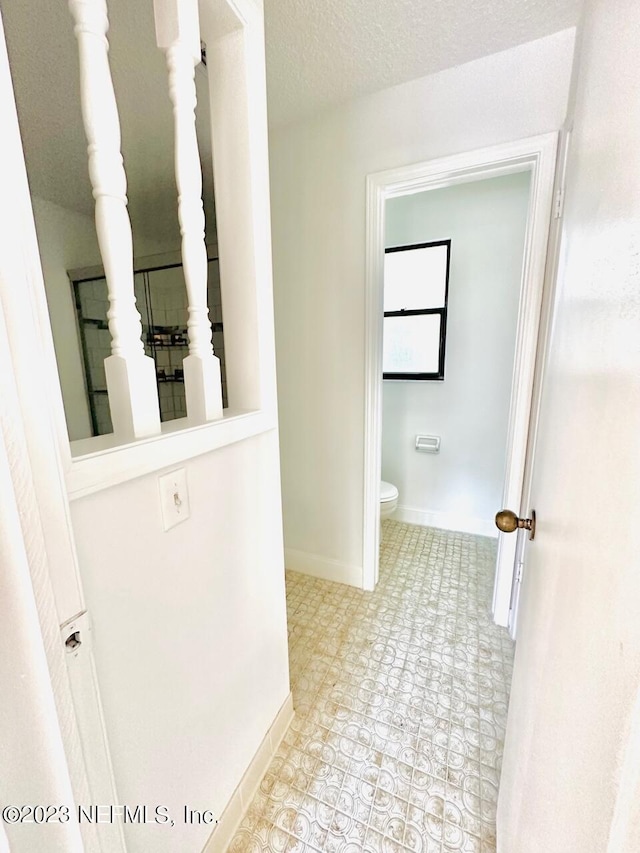 bathroom with toilet and a textured ceiling