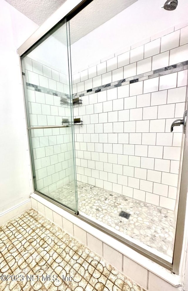 bathroom with an enclosed shower and a textured ceiling