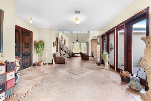 foyer entrance with ceiling fan and a textured ceiling