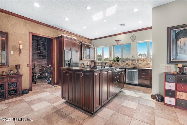 kitchen with ornamental molding, appliances with stainless steel finishes, a center island, and dark brown cabinets