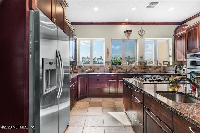 kitchen featuring a wealth of natural light, stainless steel appliances, sink, and decorative backsplash