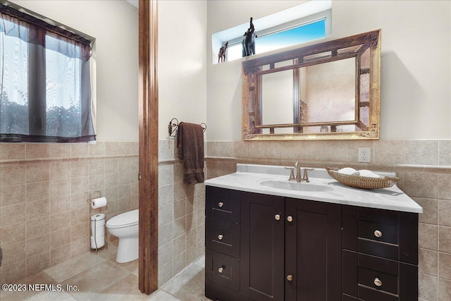 bathroom with vanity, tile walls, toilet, and tile patterned floors