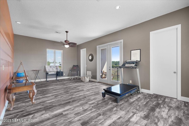 workout room with ceiling fan, a textured ceiling, and hardwood / wood-style floors