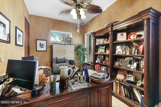 home office featuring ceiling fan and a textured ceiling