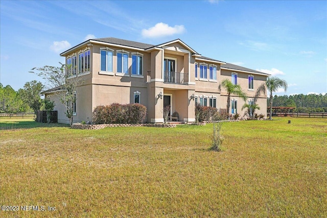 view of front of house with a front yard and a balcony