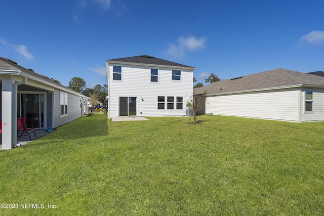 rear view of property featuring a patio and a yard