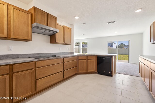 kitchen with light tile patterned flooring, black appliances, sink, and a textured ceiling