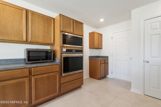 kitchen featuring appliances with stainless steel finishes and light tile patterned floors