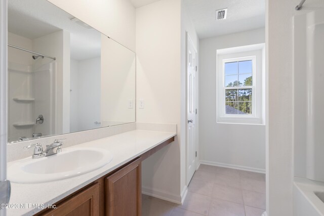 bathroom with vanity, tile patterned floors, and  shower combination