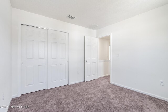 unfurnished bedroom featuring a closet and carpet