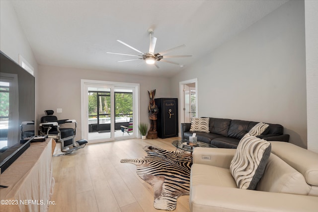 living room featuring vaulted ceiling, ceiling fan, and light wood-type flooring