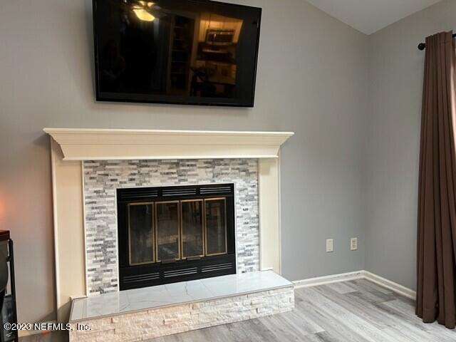 details featuring wood-type flooring and a tile fireplace