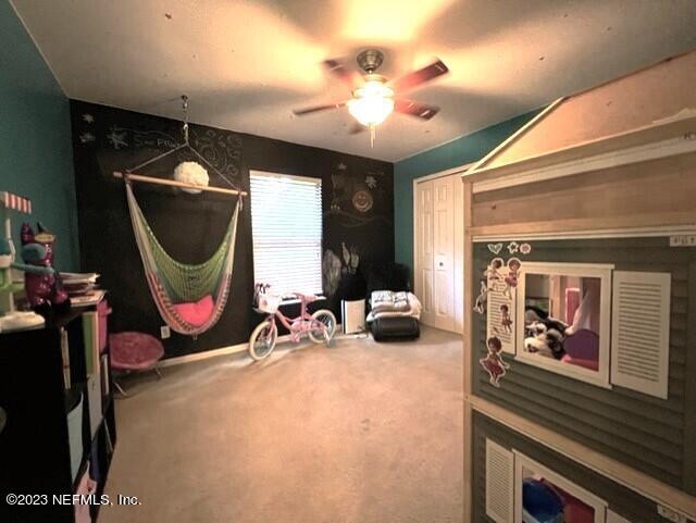 bedroom with ceiling fan, carpet flooring, and a closet