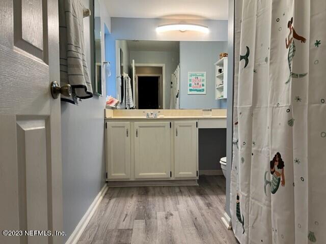 bathroom featuring vanity, toilet, and hardwood / wood-style floors