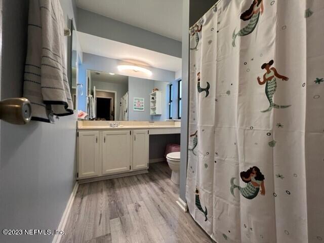 bathroom featuring vanity, hardwood / wood-style floors, and toilet