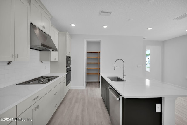 kitchen with sink, white cabinets, stainless steel appliances, and a textured ceiling