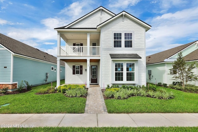 view of front of house featuring a balcony and a front yard