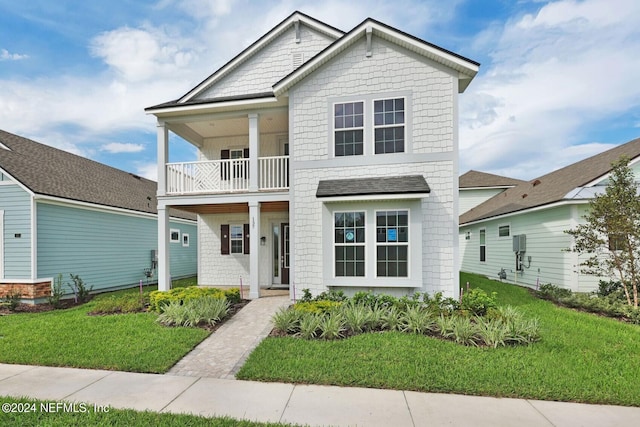 view of front of house with a balcony and a front lawn