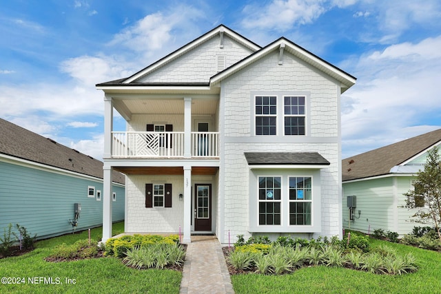 view of front of house featuring a balcony and a front yard