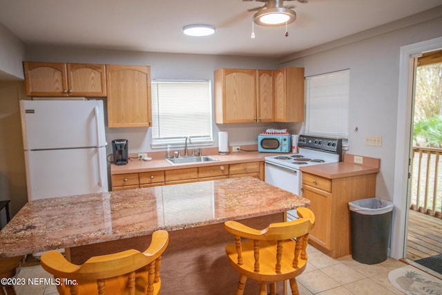 kitchen featuring light brown cabinetry, a wealth of natural light, sink, and white appliances