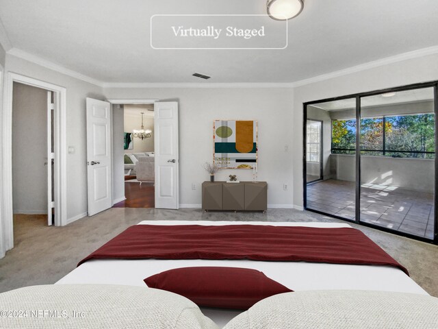 carpeted bedroom featuring access to outside, ornamental molding, and a notable chandelier