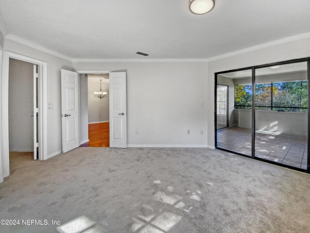 unfurnished bedroom featuring access to exterior, carpet floors, an inviting chandelier, and crown molding