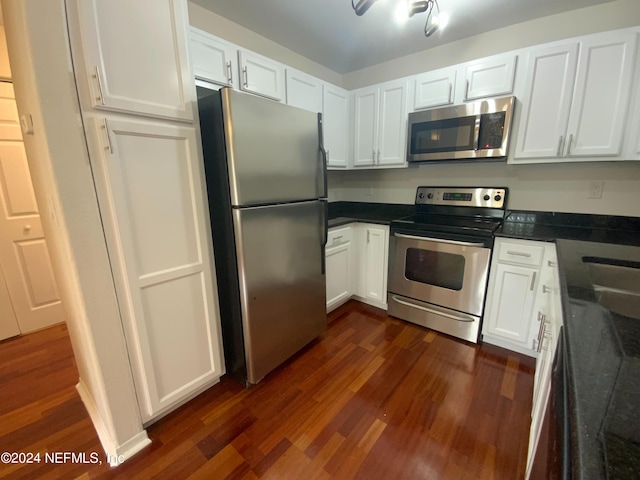 kitchen with white cabinets, appliances with stainless steel finishes, and dark wood-type flooring