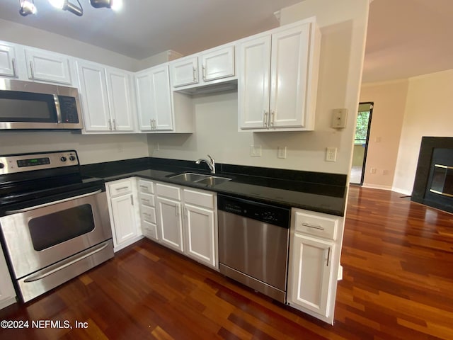 kitchen featuring dark wood-type flooring, white cabinetry, sink, and stainless steel appliances