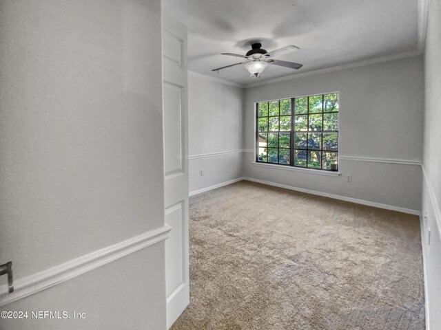 empty room featuring carpet flooring, ceiling fan, and ornamental molding