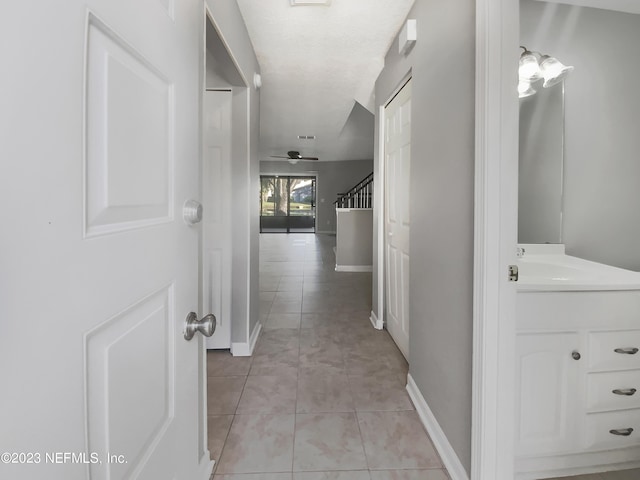 hallway featuring light tile patterned floors and sink