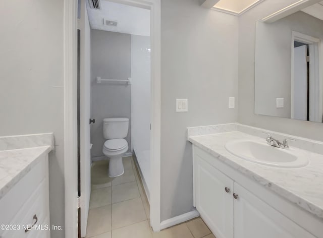 bathroom with tile patterned flooring, vanity, and toilet