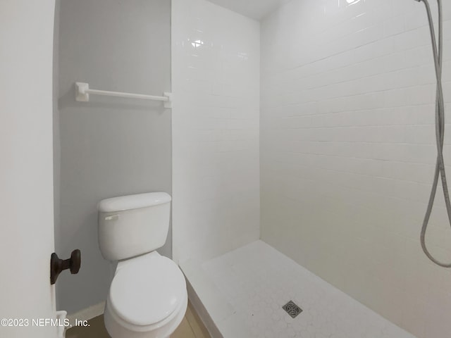 bathroom featuring a tile shower and toilet