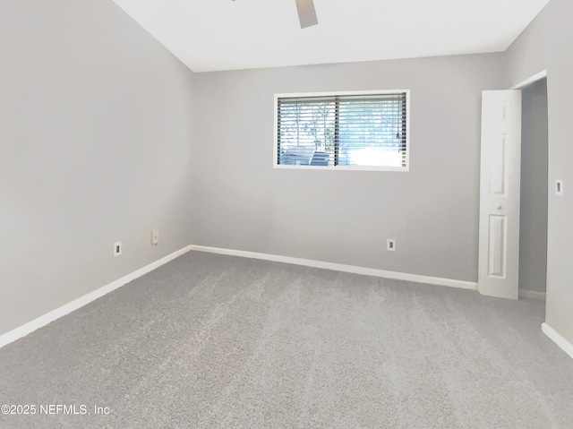 carpeted empty room featuring ceiling fan and baseboards