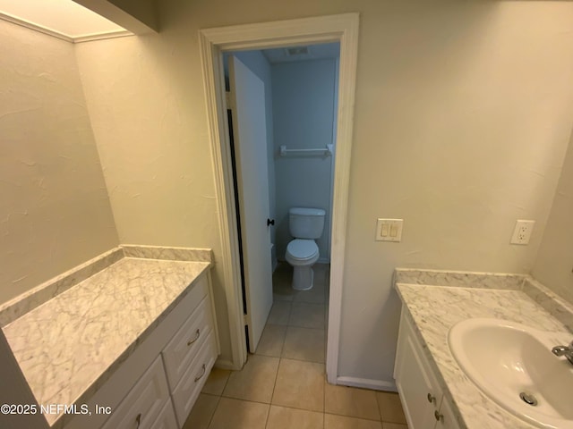 bathroom with baseboards, vanity, toilet, and tile patterned floors