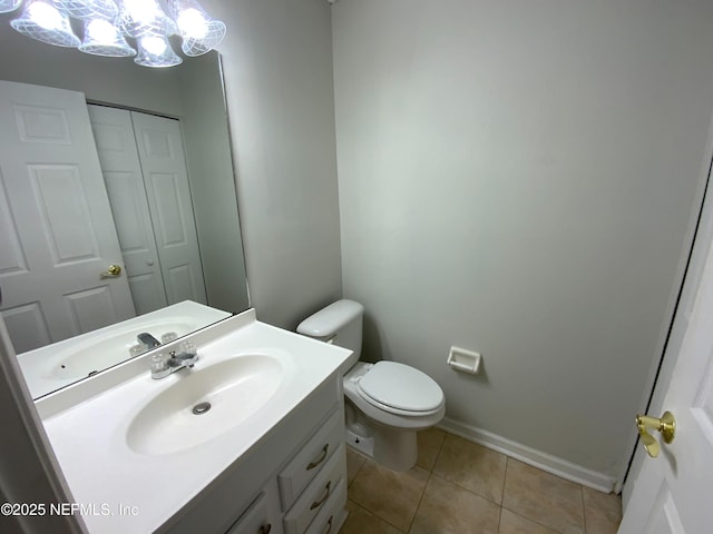 bathroom featuring tile patterned flooring, toilet, a notable chandelier, vanity, and baseboards