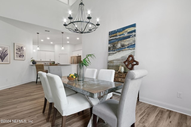 dining area featuring hardwood / wood-style floors and an inviting chandelier