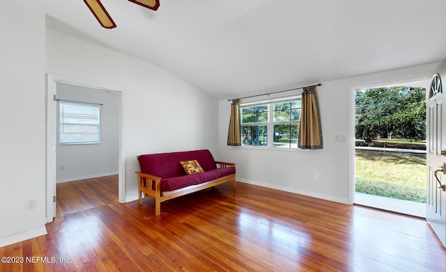 living area with ceiling fan, lofted ceiling, and hardwood / wood-style flooring