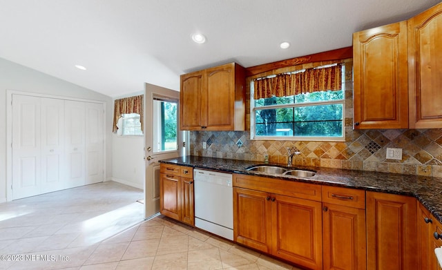 kitchen with dishwasher, sink, tasteful backsplash, dark stone counters, and lofted ceiling