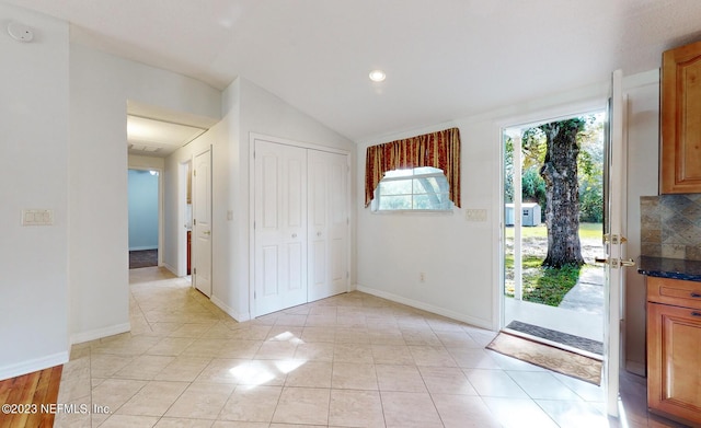 tiled entrance foyer featuring vaulted ceiling