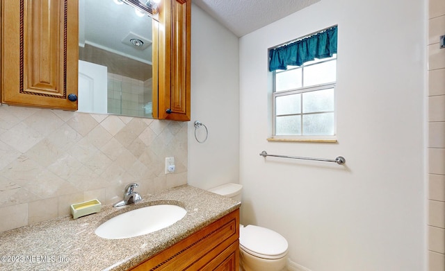 bathroom with tasteful backsplash, vanity, and toilet