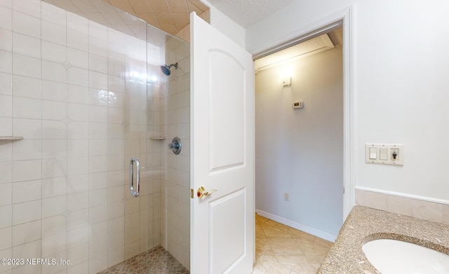 bathroom featuring a textured ceiling, vanity, and a shower with shower door