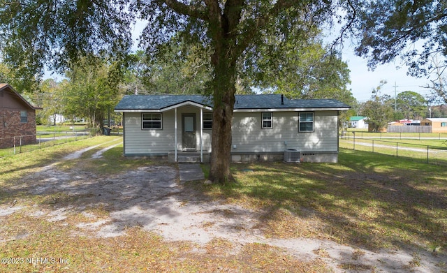 back of house with central AC unit and a lawn