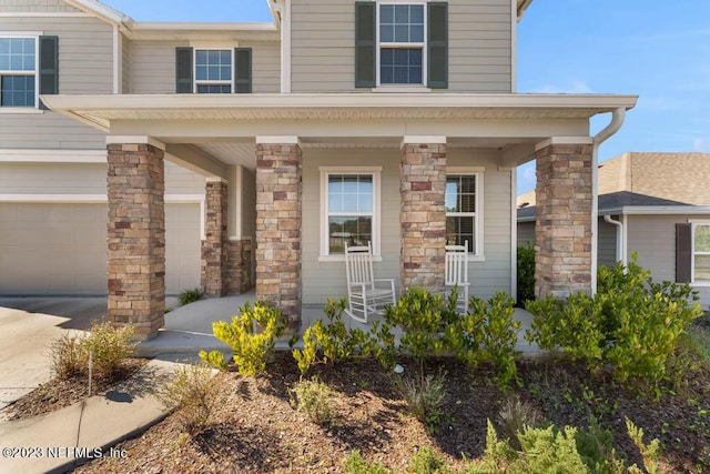 doorway to property featuring a garage and a porch