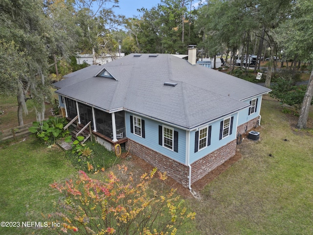 back of property featuring a yard, central AC unit, and a sunroom