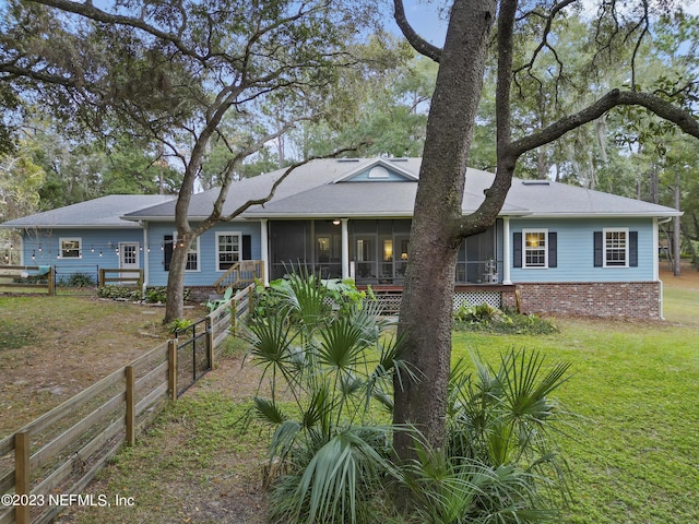 view of front facade featuring a sunroom and a front lawn