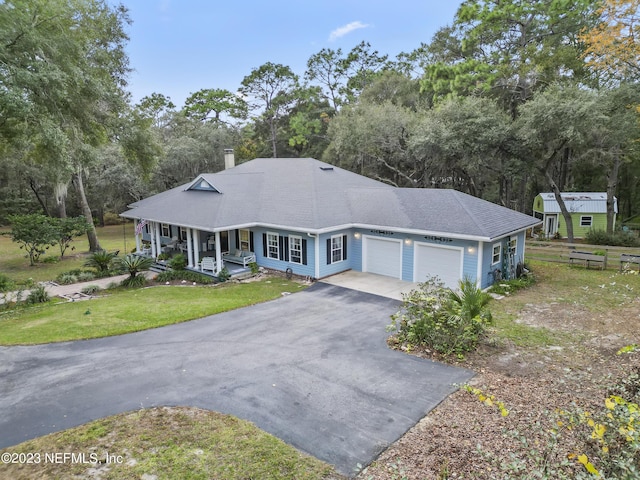 view of front of house featuring a garage, a front yard, and a porch