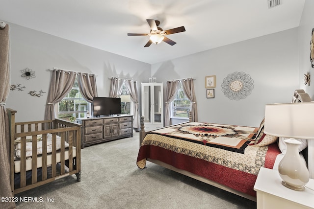 carpeted bedroom featuring multiple windows and ceiling fan