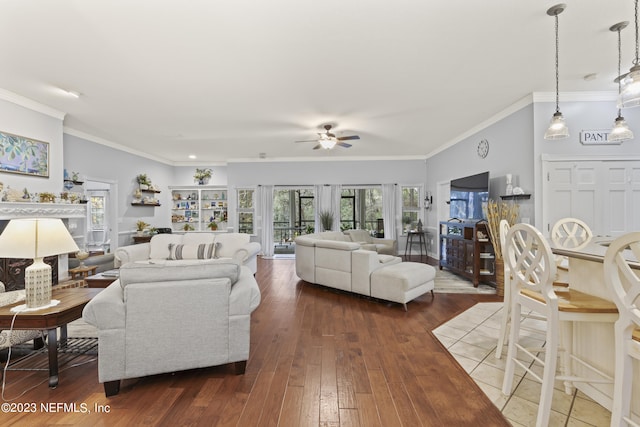 living room featuring crown molding, wood-type flooring, and ceiling fan